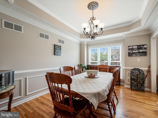 114 New Market Dr, Stephens City, VA 22655 - dining room with a tray ceiling, light wood-style floors, a chandelier, ornamental molding, and wainscoting