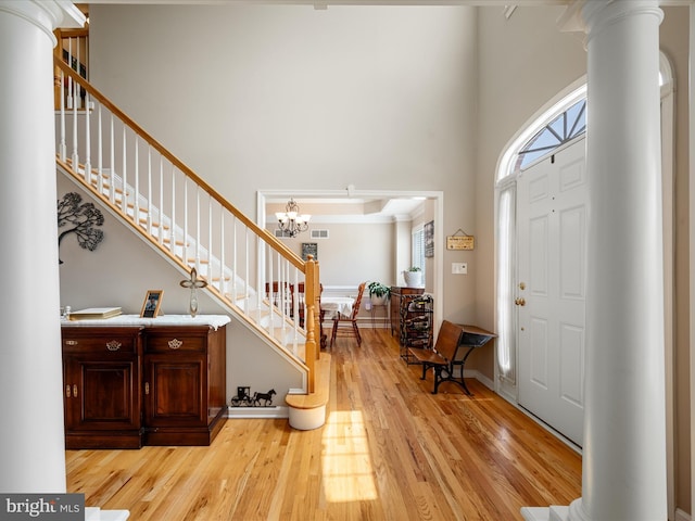 114 New Market Dr, Stephens City, VA 22655 - entrance foyer with ornate columns, light wood-style flooring, stairway, a towering ceiling, and a chandelier