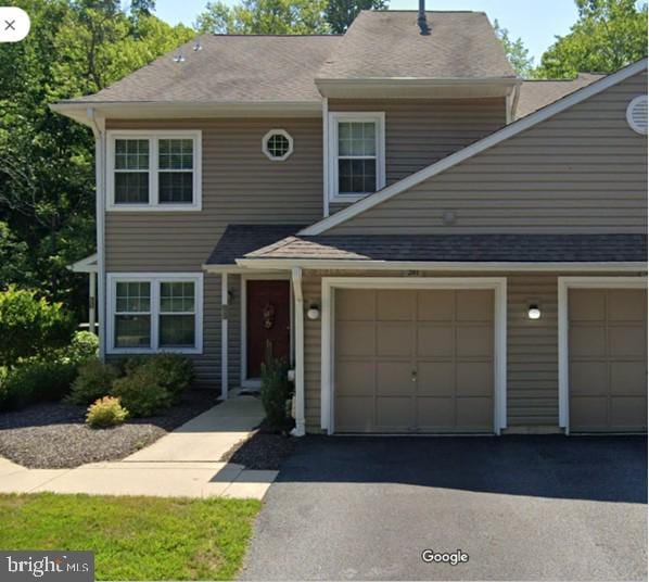 view of front of home with a garage, a shingled roof, and aphalt driveway