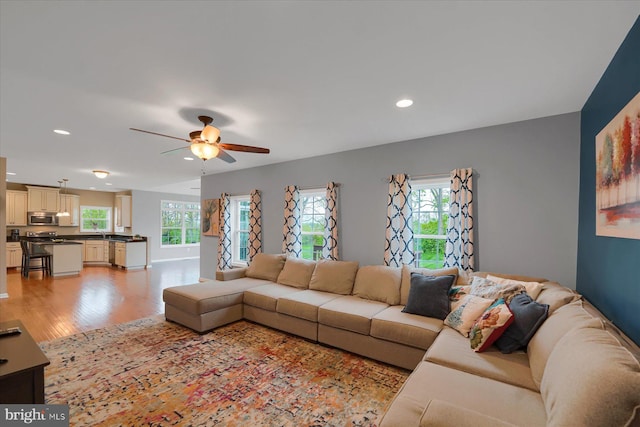 living room with light wood-style floors, a ceiling fan, and recessed lighting