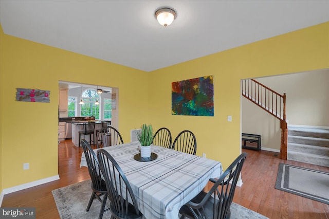 dining space with stairway, wood finished floors, baseboards, and visible vents