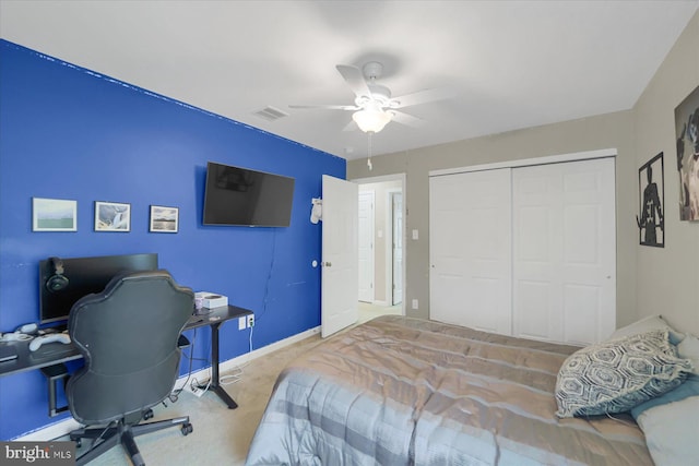 carpeted bedroom featuring a closet, visible vents, baseboards, and ceiling fan