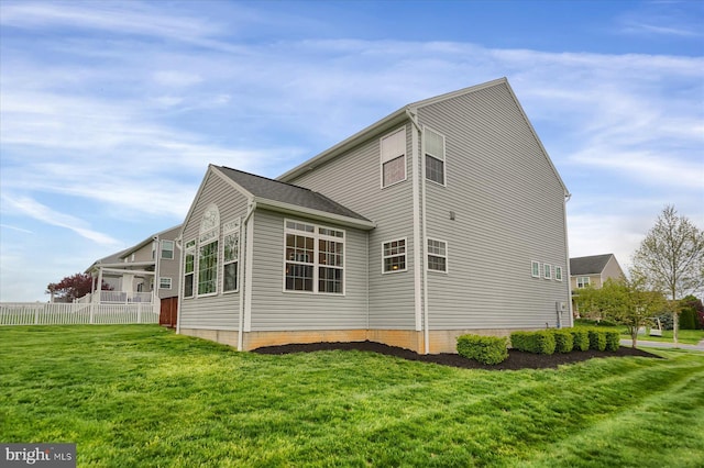 view of property exterior featuring fence and a lawn