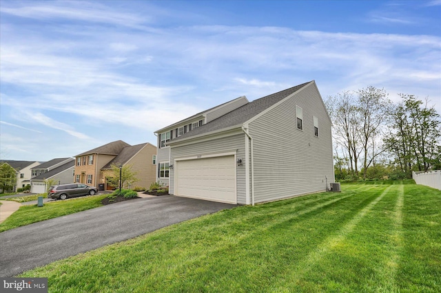 exterior space with a residential view, central AC, aphalt driveway, a shingled roof, and a yard
