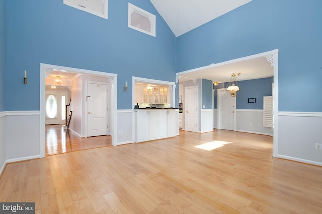 729 Rosecroft Ct, Forest Hill, MD 21050 - unfurnished living room featuring light wood finished floors, high vaulted ceiling, a ceiling fan, and wainscoting