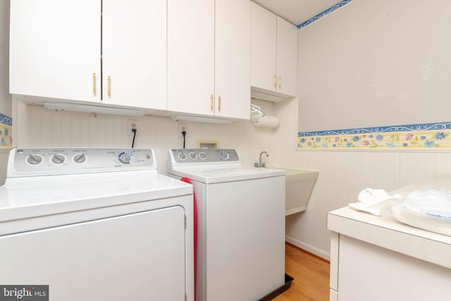 729 Rosecroft Ct, Forest Hill, MD 21050 - laundry room featuring cabinet space, washer and dryer, light wood-style flooring, and a wainscoted wall