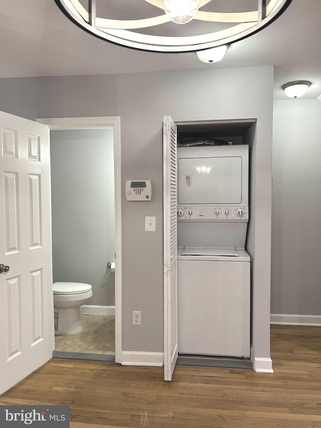 371 Chaplin St SE, Washington, DC 20019 - laundry room with stacked washer and clothes dryer, wood finished floors, and baseboards