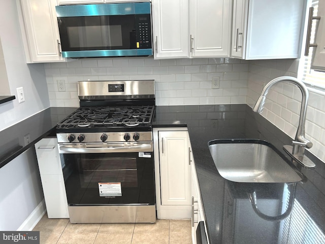 371 Chaplin St SE, Washington, DC 20019 - kitchen featuring stainless steel appliances, a sink, white cabinets, dark countertops, and backsplash