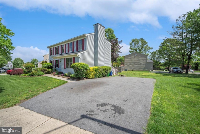 9402 Glen Ridge Dr, Laurel, MD 20723 - view of front facade featuring a chimney, a front yard, and asphalt driveway