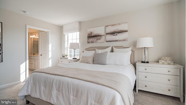 bedroom with connected bathroom, baseboards, and carpet