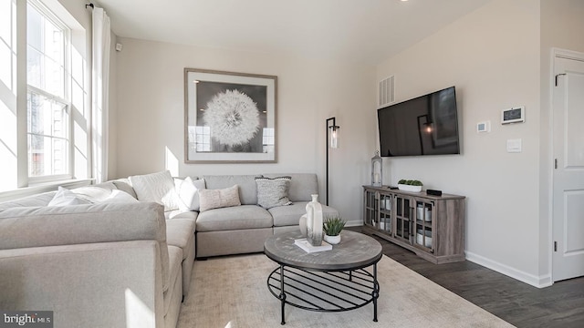 living area with baseboards, wood finished floors, and visible vents