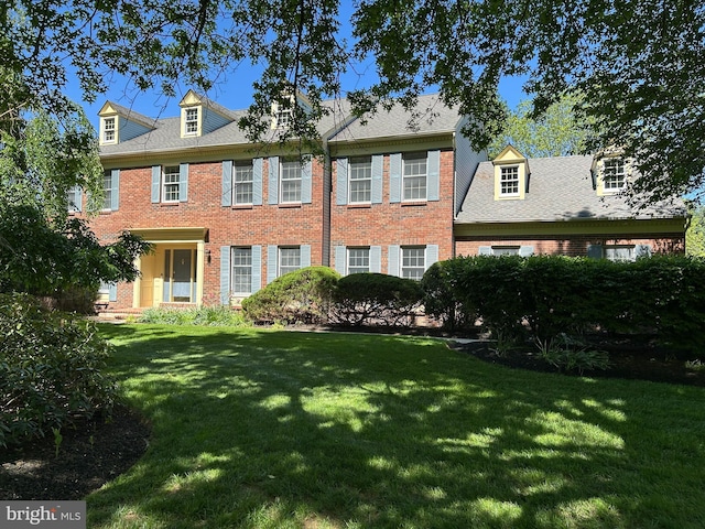 view of front facade featuring brick siding and a front yard