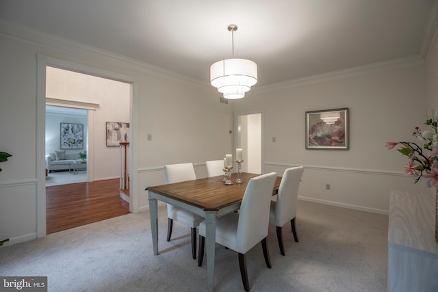 dining area featuring light carpet and crown molding