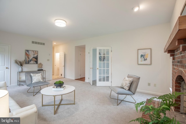 carpeted living room featuring a brick fireplace, baseboards, and french doors