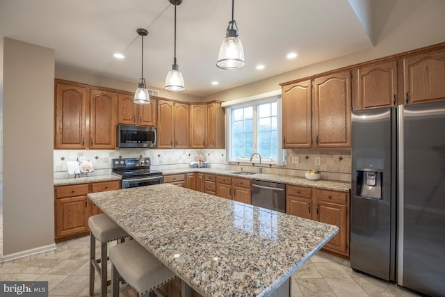 kitchen featuring stainless steel appliances, tasteful backsplash, a kitchen breakfast bar, light stone countertops, and recessed lighting