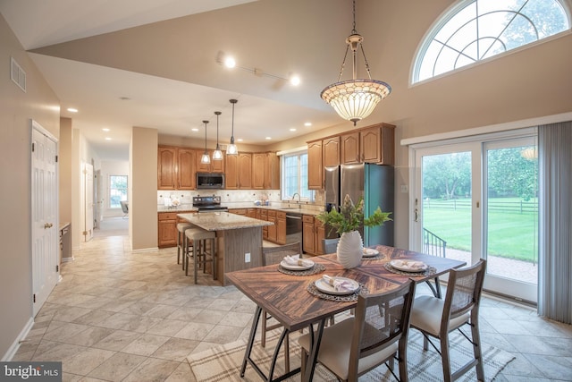 dining space with healthy amount of natural light, recessed lighting, baseboards, and light stone finish flooring