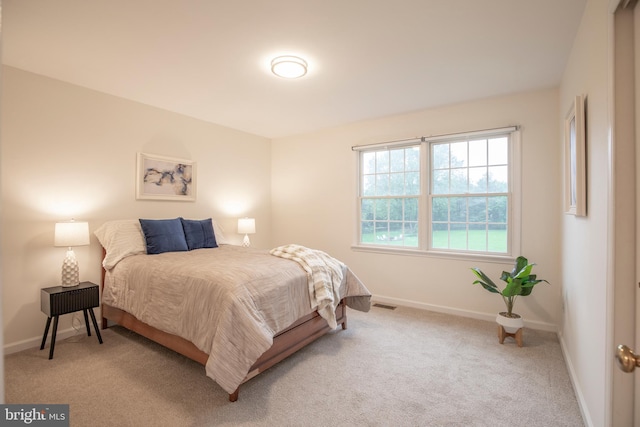 bedroom featuring baseboards and light colored carpet