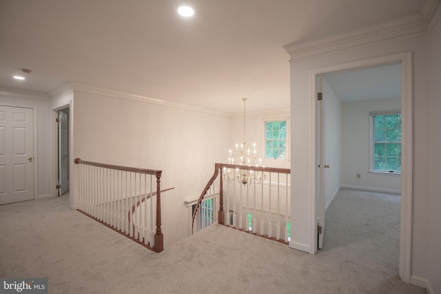 hallway featuring an upstairs landing, carpet flooring, a chandelier, crown molding, and baseboards