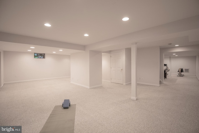 finished basement featuring recessed lighting, light carpet, and baseboards