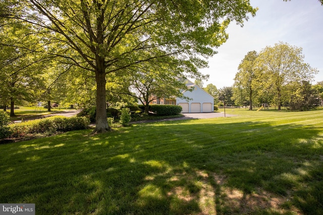 view of green lawn featuring a garage