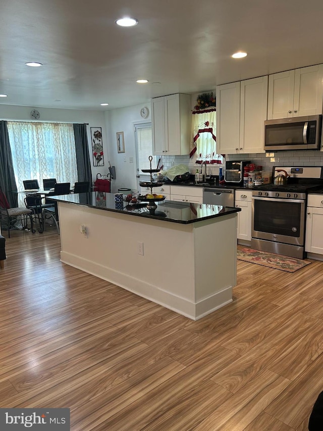 1305 Wendover Ct, District Heights, MD 20747 - kitchen with stainless steel appliances, dark countertops, light wood finished floors, tasteful backsplash, and white cabinetry