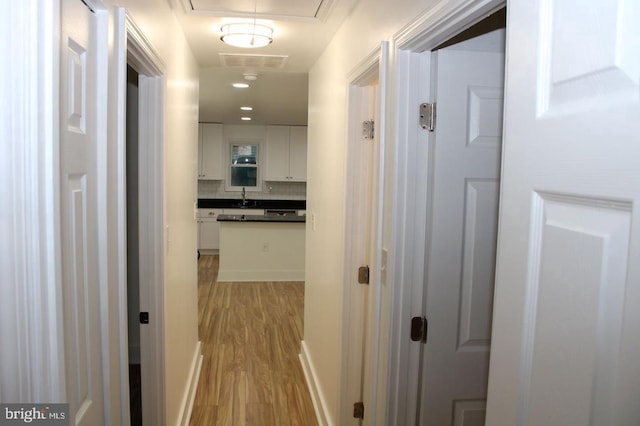 1305 Wendover Ct, District Heights, MD 20747 - corridor featuring a sink, light wood-type flooring, and attic access