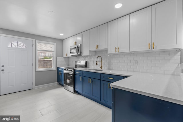 1213 Washington Blvd, Baltimore, MD 21230 - kitchen featuring appliances with stainless steel finishes, blue cabinets, a sink, white cabinets, and backsplash