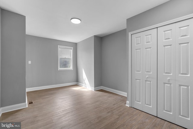 1213 Washington Blvd, Baltimore, MD 21230 - unfurnished bedroom with wood finished floors, baseboards, and a closet