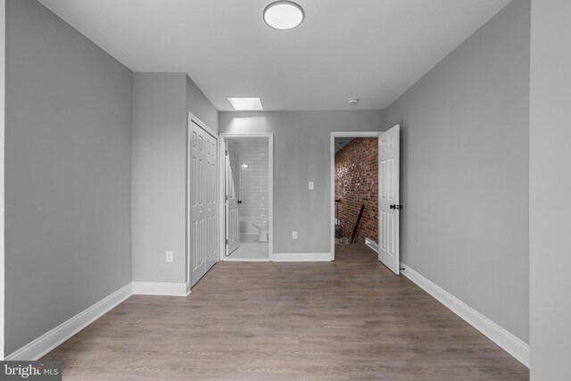 1213 Washington Blvd, Baltimore, MD 21230 - unfurnished bedroom with baseboards, wood finished floors, and ensuite bathroom