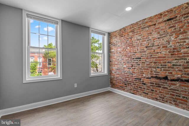 1213 Washington Blvd, Baltimore, MD 21230 - spare room with baseboards, wood finished floors, brick wall, and healthy amount of natural light