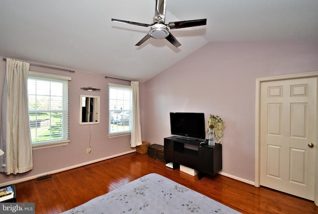 bedroom featuring baseboards, visible vents, wood finished floors, and lofted ceiling