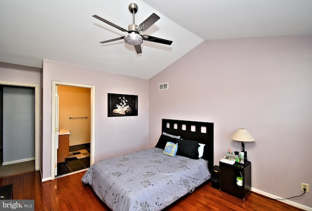 bedroom featuring visible vents, wood finished floors, baseboards, connected bathroom, and vaulted ceiling