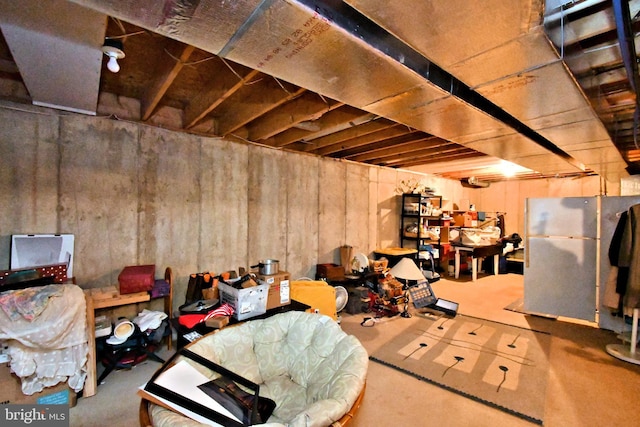 unfinished below grade area featuring freestanding refrigerator