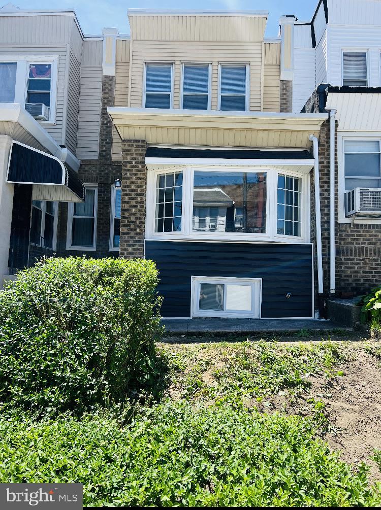 rear view of property featuring brick siding and cooling unit