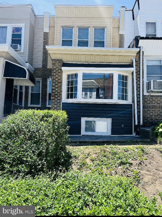 rear view of property featuring brick siding and cooling unit