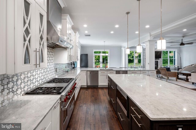 kitchen featuring open floor plan, wall chimney range hood, dark wood-type flooring, recessed lighting, and stainless steel appliances