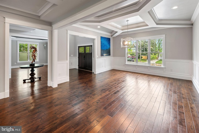 unfurnished living room featuring coffered ceiling, a notable chandelier, dark wood-style floors, and a wealth of natural light