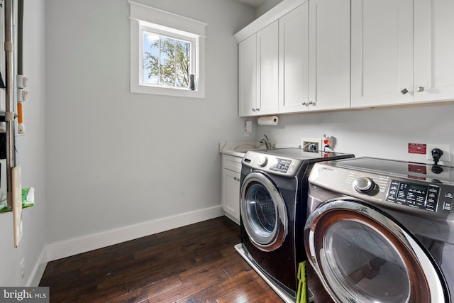 laundry room featuring baseboards, dark wood finished floors, cabinet space, and washer and clothes dryer