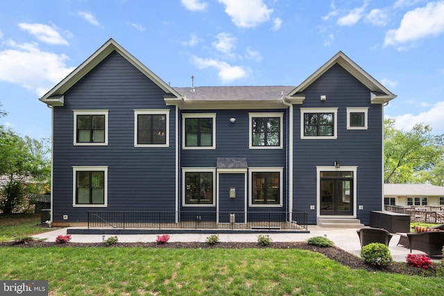 back of house with a yard and a patio