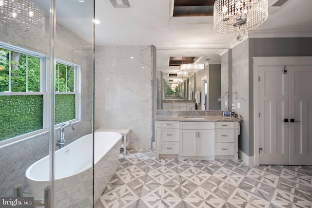 full bathroom featuring vanity, a freestanding tub, a notable chandelier, and visible vents