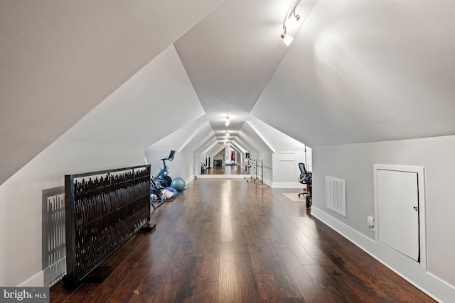 additional living space featuring baseboards, vaulted ceiling, wood finished floors, and visible vents