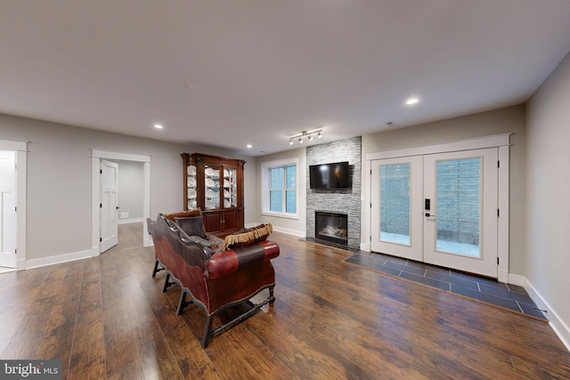 living area featuring baseboards, a fireplace, recessed lighting, and wood finished floors