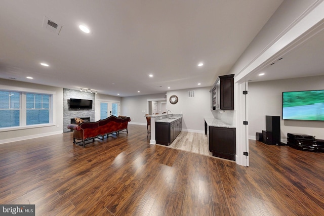 living room featuring visible vents, a fireplace, recessed lighting, and wood finished floors