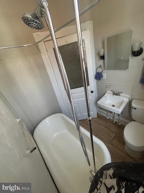 bathroom featuring a sink, toilet, and wood finished floors