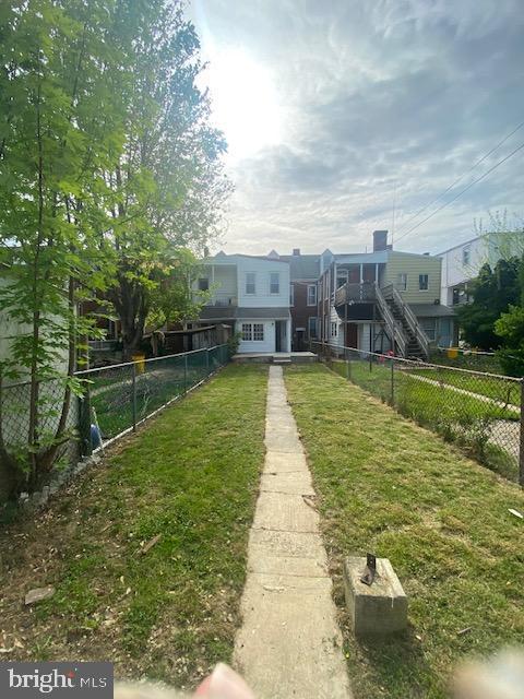 view of community with a lawn and a fenced backyard