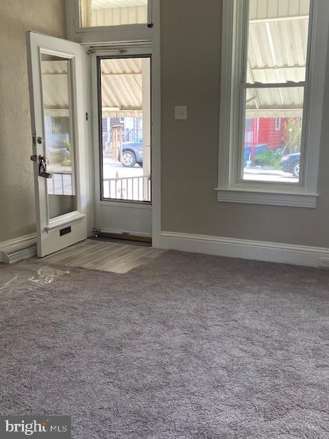 interior space with baseboards and carpet