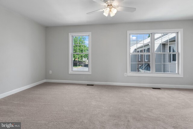 unfurnished room with a ceiling fan, baseboards, visible vents, and carpet