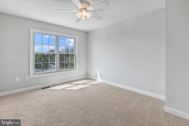 empty room with baseboards, carpet floors, and visible vents