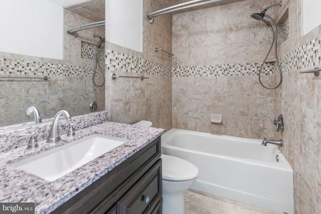 full bathroom with vanity, tile walls, toilet, and shower / tub combination