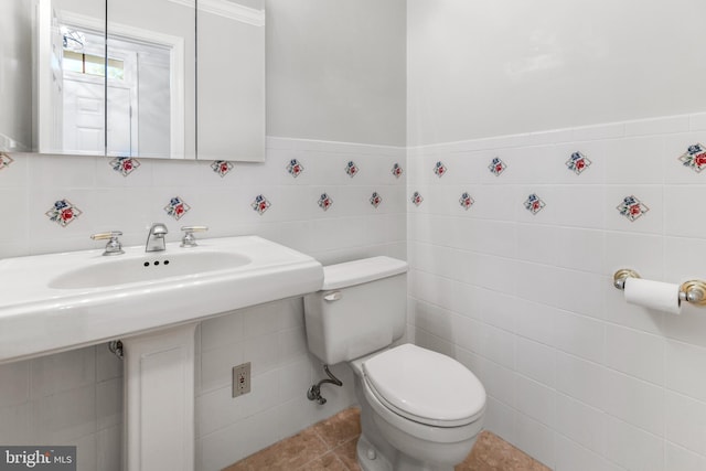 bathroom featuring tile walls and toilet